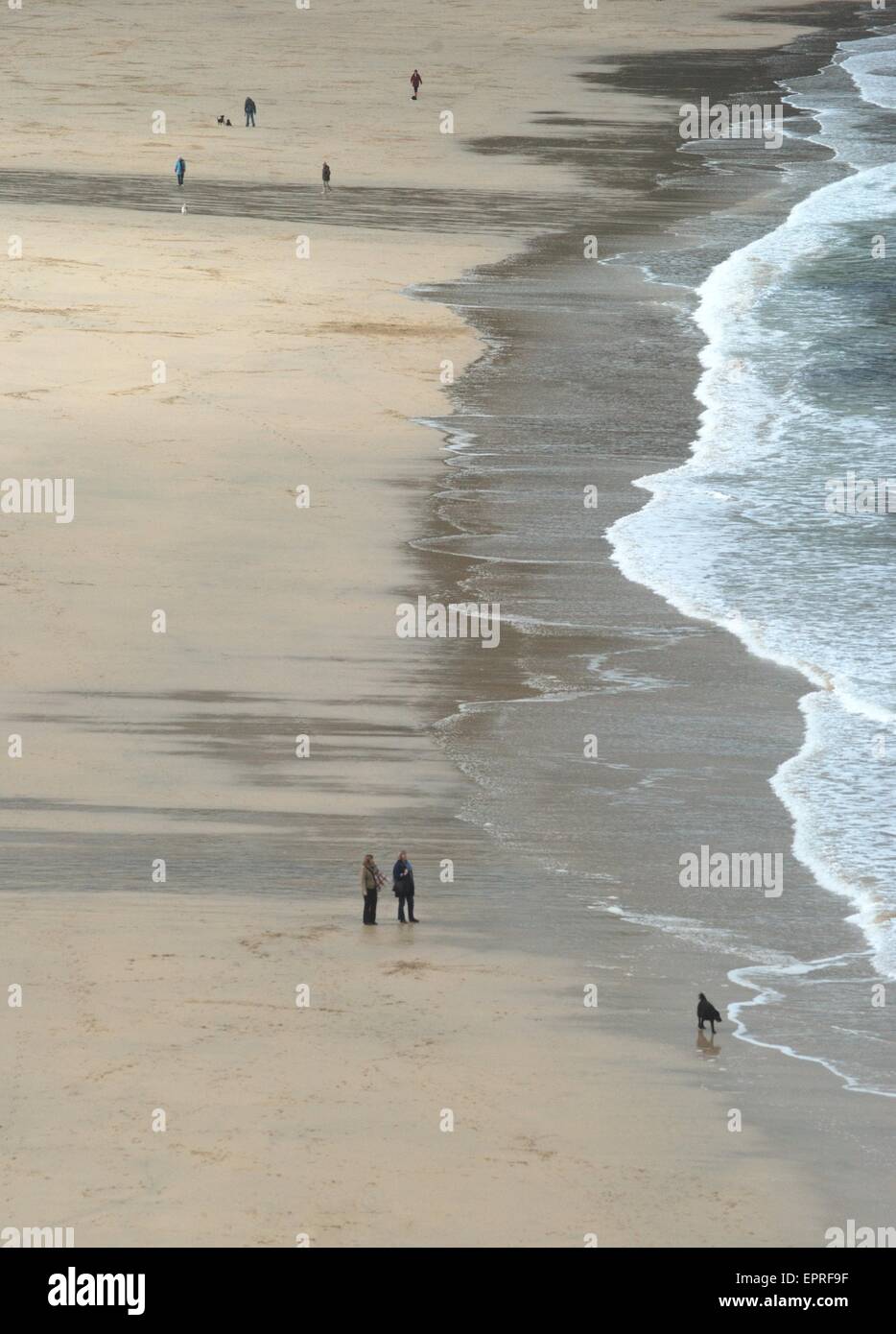 Menschen, die im Februar mit Hund am Strand spazieren gehen, St Ives, Cornwall, Großbritannien Stockfoto