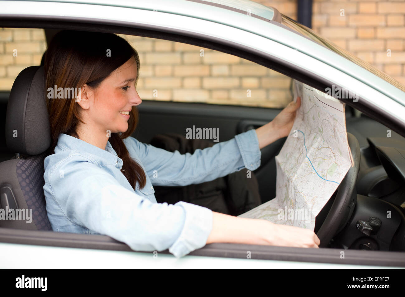 junge Frau in ihrem Auto Kartenlesen Stockfoto