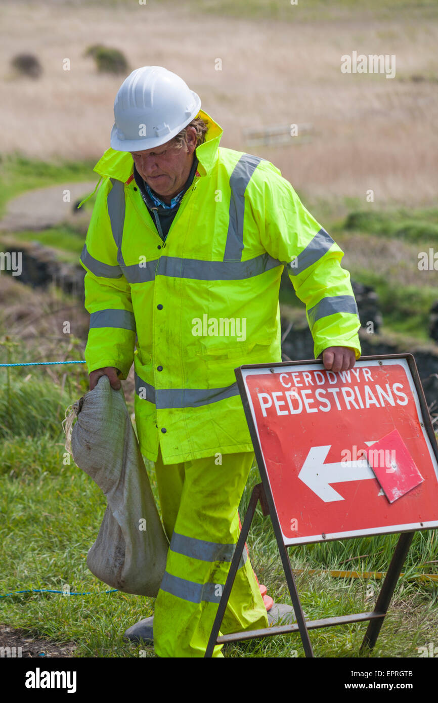 Arbeiter mit Fußgänger-Umlenkschild - Arbeiter legen neuen Weg in Porthgain, Pembrokeshire Coast National Park, Wales, Großbritannien im Mai Stockfoto