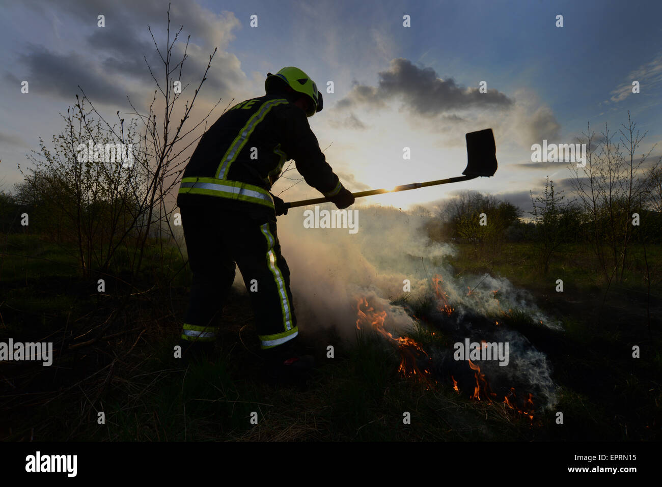 Ein Feuerwehrmann Außerbetriebnahme Flammen an einem Feld Feuer. Bild: Scott Bairstow/Alamy Stockfoto
