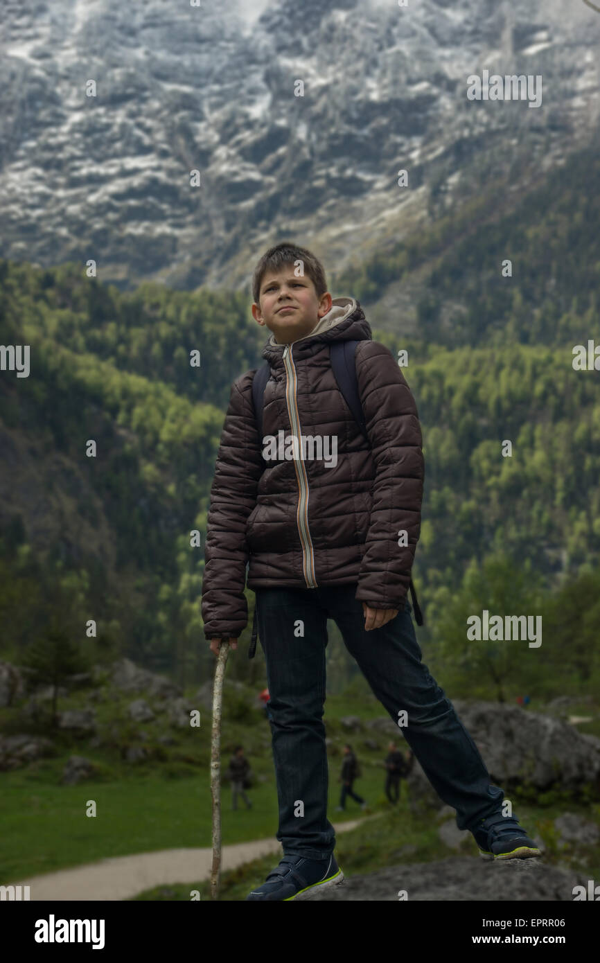 Junge Junge stand auf dem Felsen auf einem Berg-Hintergrund Stockfoto