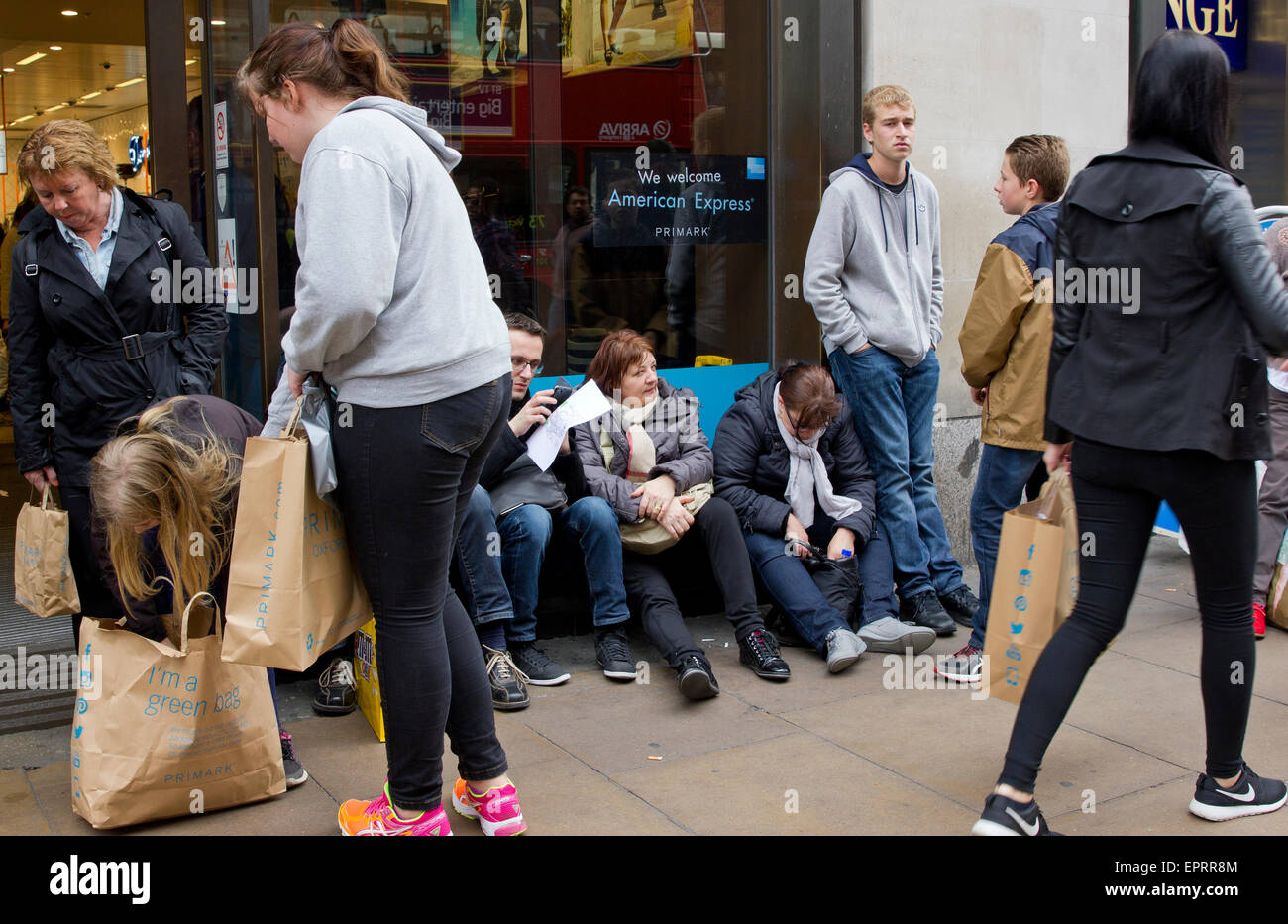 Käufer außerhalb ruhen Sie sich nach Kauf bei Primark Oxford Street, London Stockfoto