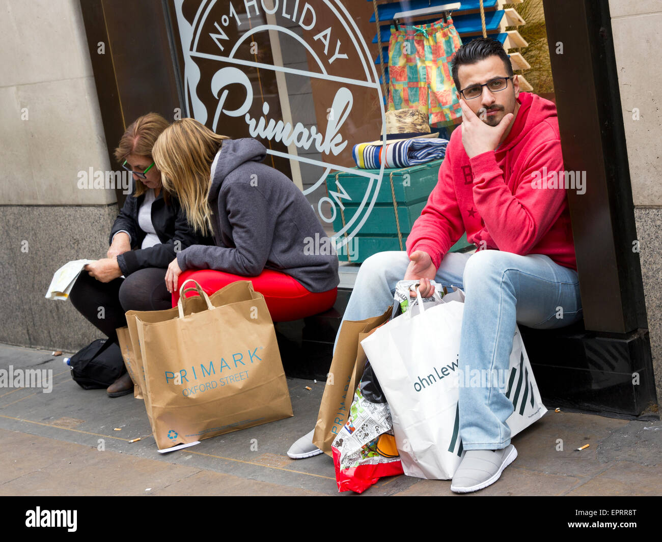 Käufer außerhalb ruhen Sie sich nach Kauf bei Primark Oxford Street, London Stockfoto