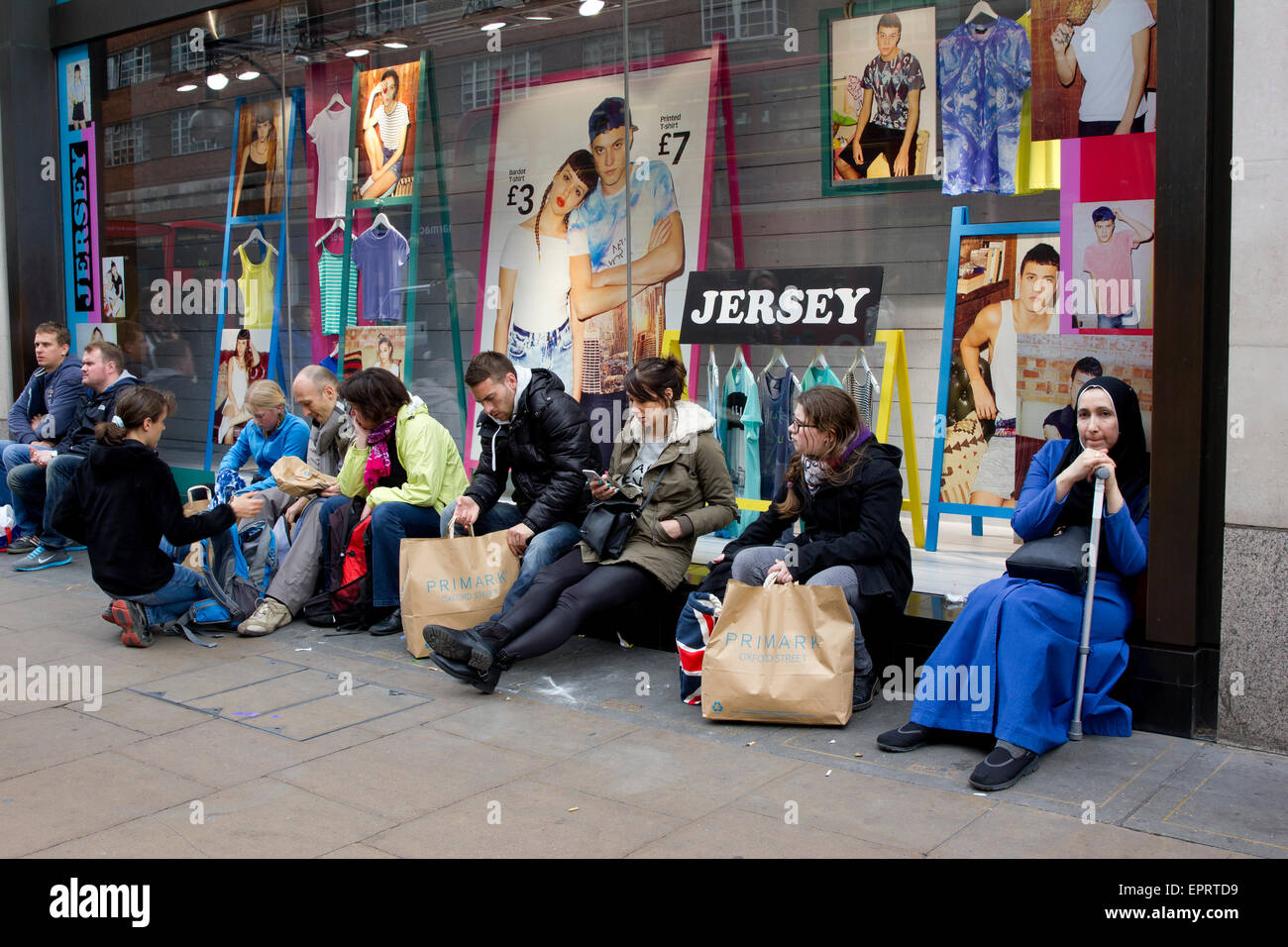 Käufer außerhalb ruhen Sie sich nach Kauf bei Primark Oxford Street, London Stockfoto