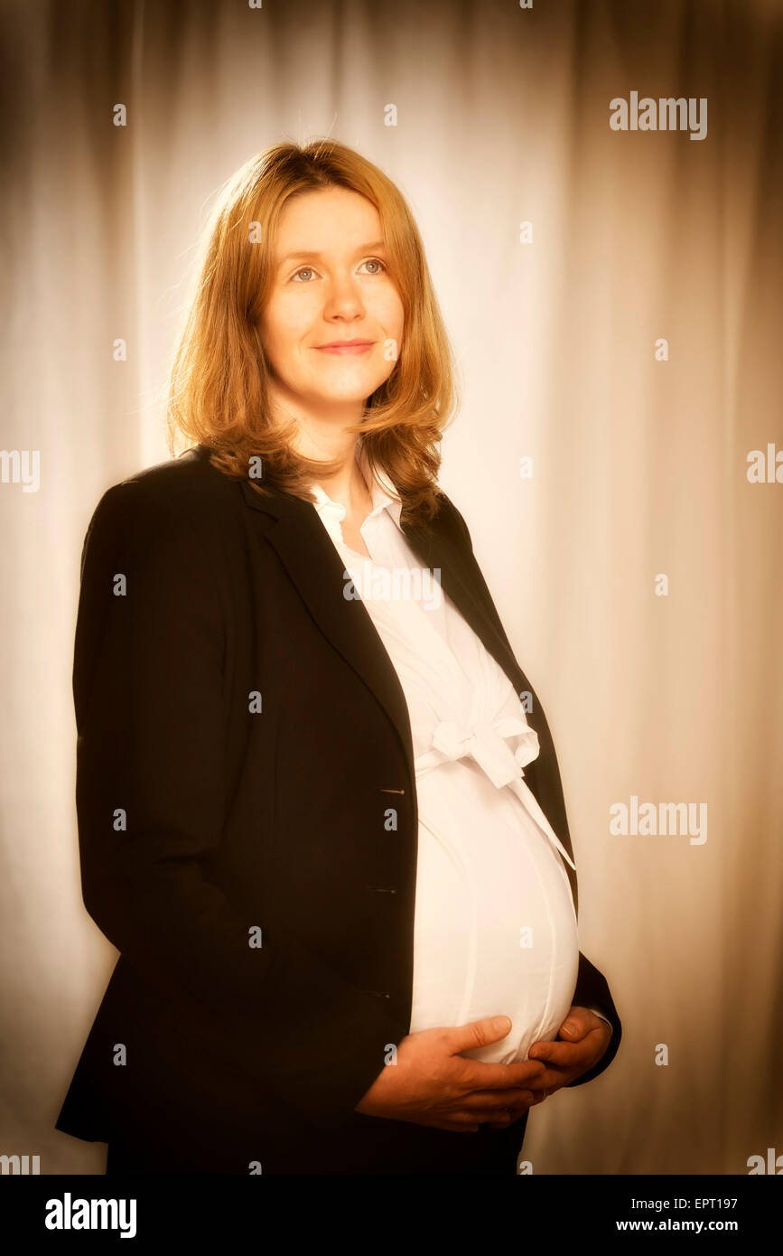 Schwangere blonde Geschäftsfrau im schwarzen Business-Bekleidung Stockfoto