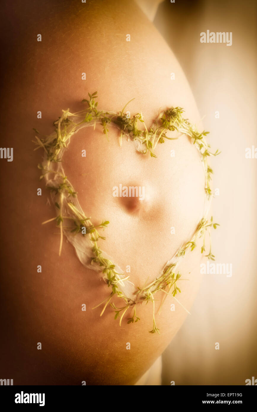 Bild von einem Baby-Bauch mit Creme Kresse Herzen in der warmen Sonnenlicht Stockfoto