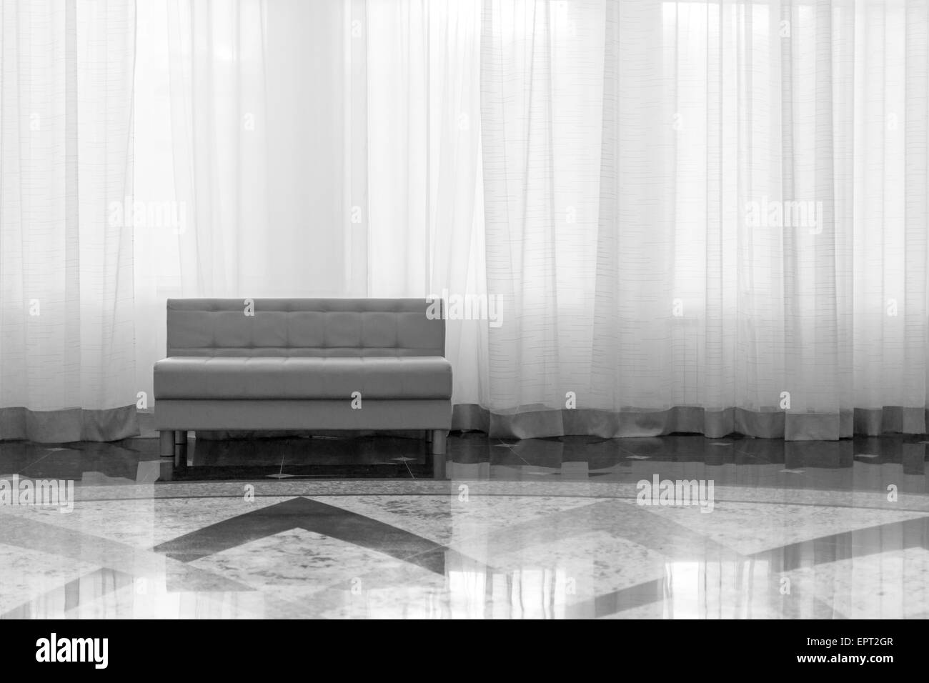 Elegante moderne Möbel gegen einen großen Vorhang in schwarz / weiß Stockfoto