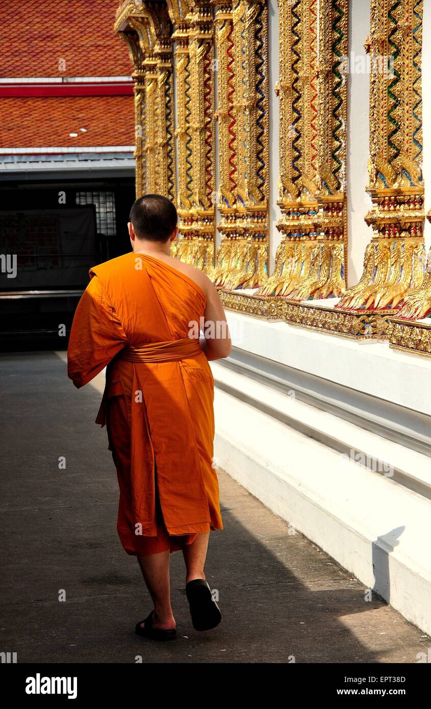 Bangkok, Thailand: Mönch in orange Gewand ein Spaziergang vorbei an der Ubosot Heiligtum Halle am Wat Chanasongkhram Stockfoto