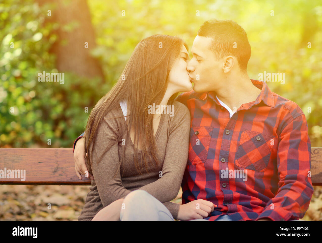 Paar Küssen auf der Bank im park Stockfoto