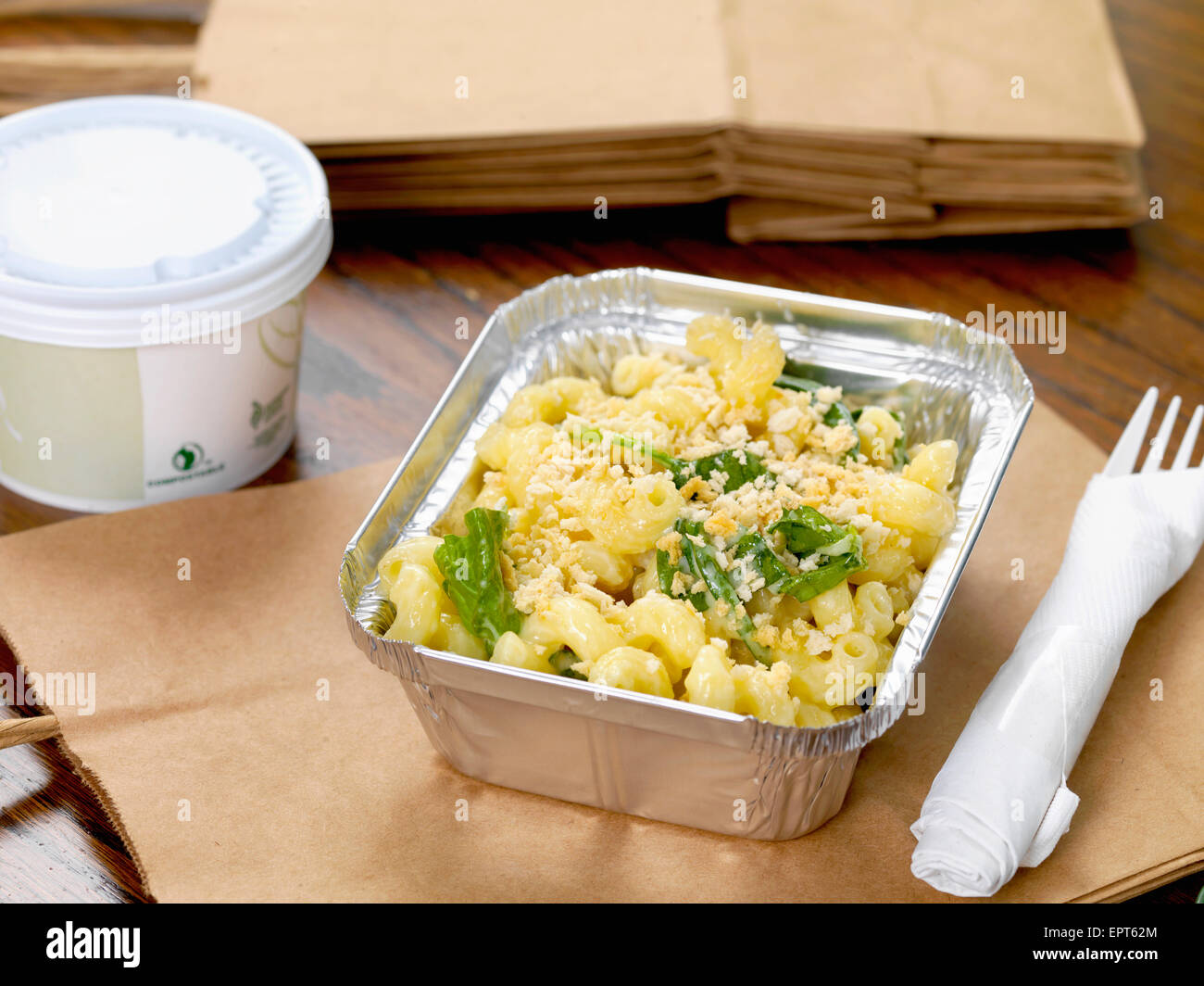 Gourmet-Mac and Cheese mit Kunststoff Gabel und Suppe und braunen Papiertüten zum mitnehmen Stockfoto