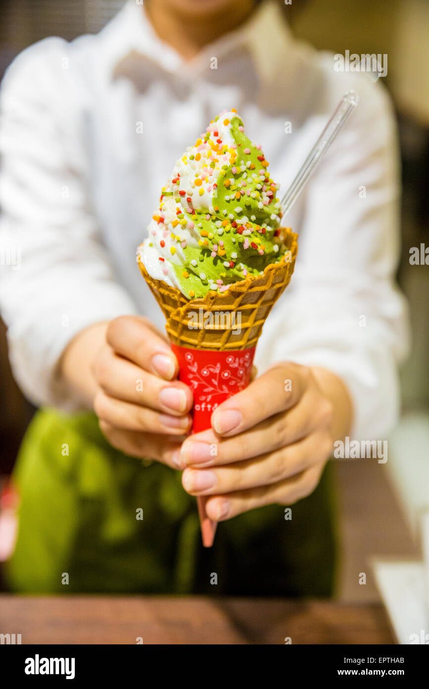 Mädchen in der Hand aus Matcha-Grüntee-Eis Stockfoto