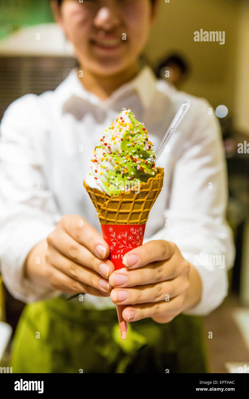 Mädchen in der Hand aus Matcha-Grüntee-Eis Stockfoto