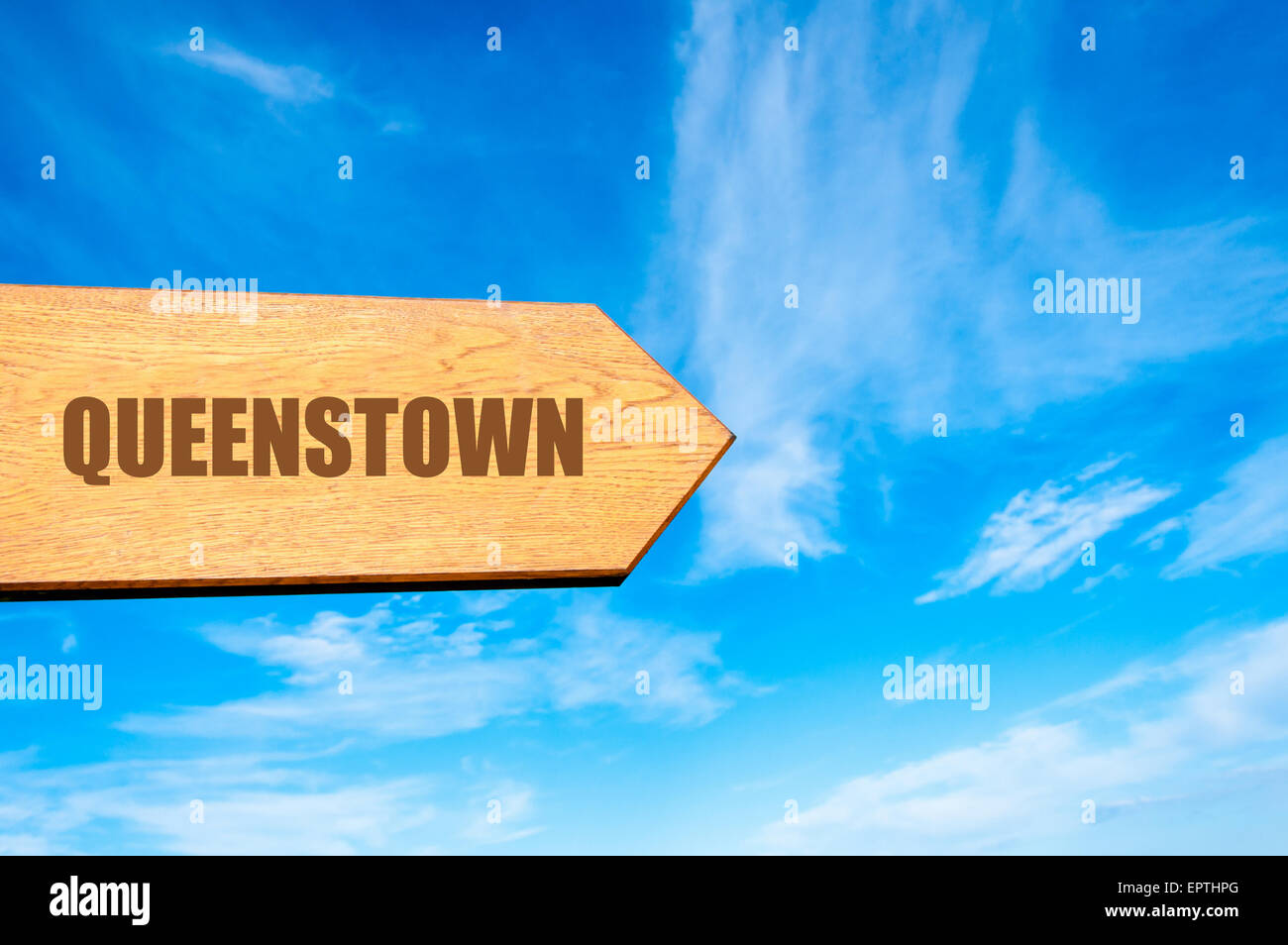 Hölzerne Pfeil Zeichen zeigenden Destination QUEENSTOWN, Neuseeland gegen strahlend blauen Himmel mit textfreiraum zur Verfügung. Zielbild Konzept Reisen Stockfoto