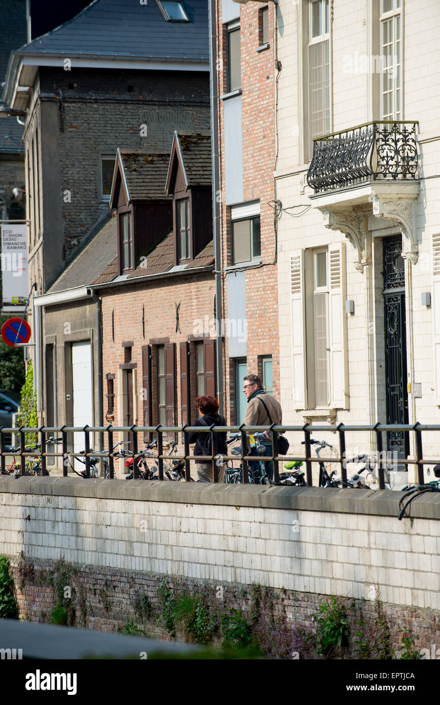 Zwei Menschen stehen am Wasser in einer malerischen Straße mit Gebäuden im Hintergrund Stockfoto