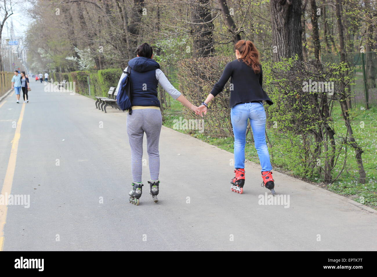 Zwei Damen, die Hand in Hand während Rollerskating, Bukarest, Rumänien Stockfoto