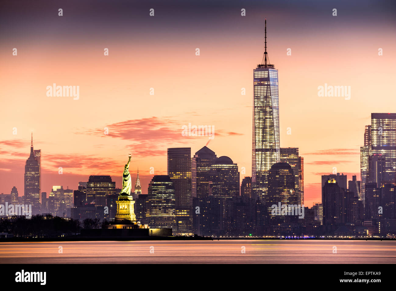 Lower Manhattan mit Freedom Tower und The Statue of Liberty bei Sonnenaufgang Stockfoto