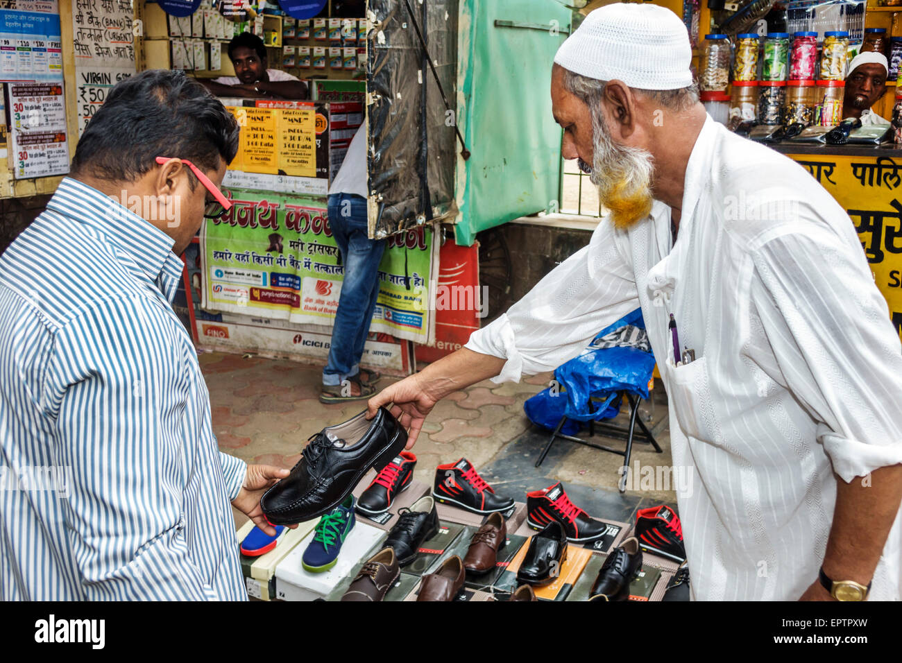 Mumbai Indien, Indischer Asiatisch, Dharavi, Shahu Nagar Road, Slum, niedriges Einkommen, arm, Armut, Erwachsene Erwachsene Erwachsene Männer Männer männlich, arbeitend, muslimisch, Männer, Schuhe, Verkauf, Verkauf, Kunde Stockfoto