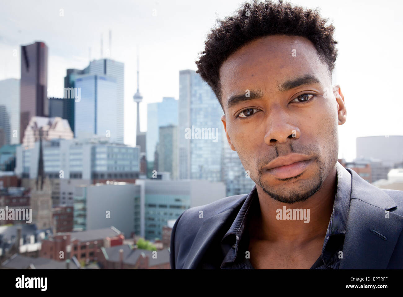 Attraktive afro-amerikanische Business Mann posiert im Studio vor der Innenstadt von Toronto Stockfoto