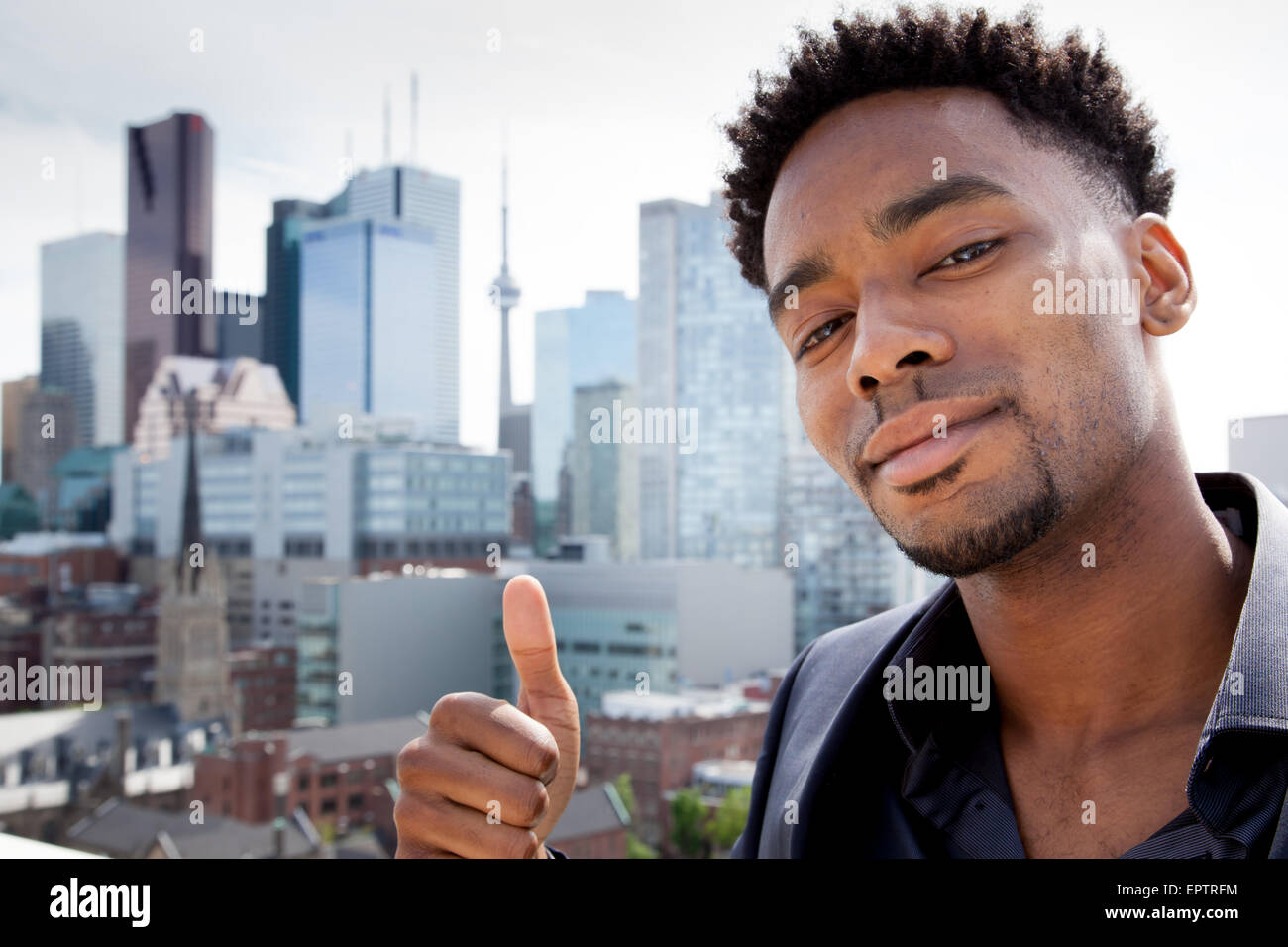Attraktive afro-amerikanische Business Mann posiert im Studio vor der Innenstadt von Toronto Stockfoto