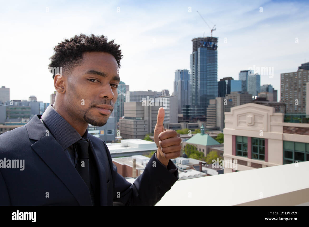 Attraktive afro-amerikanische Business Mann posiert im Studio vor der Innenstadt von Toronto Stockfoto