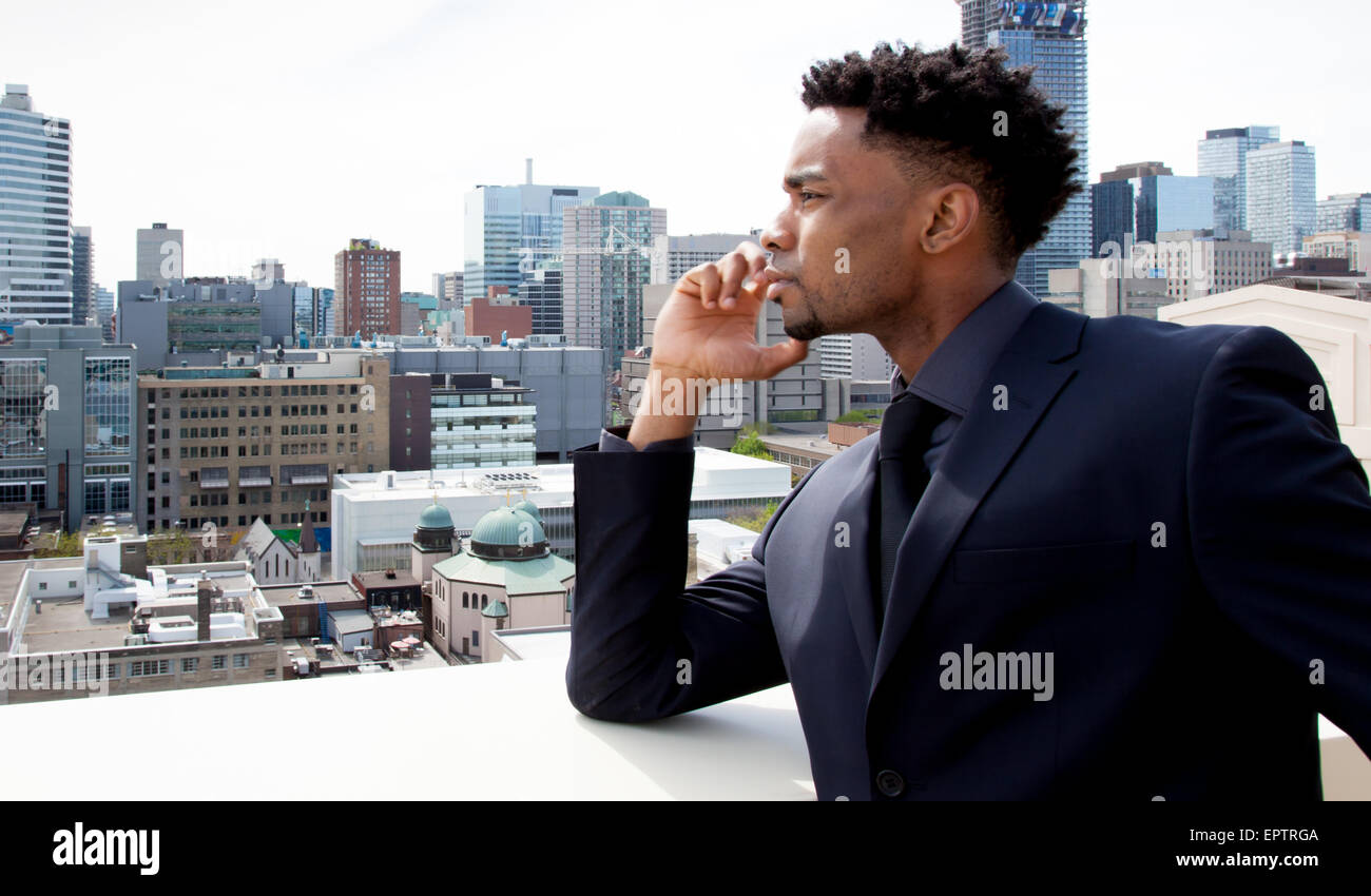Attraktive afro-amerikanische Business Mann posiert im Studio vor der Innenstadt von Toronto Stockfoto