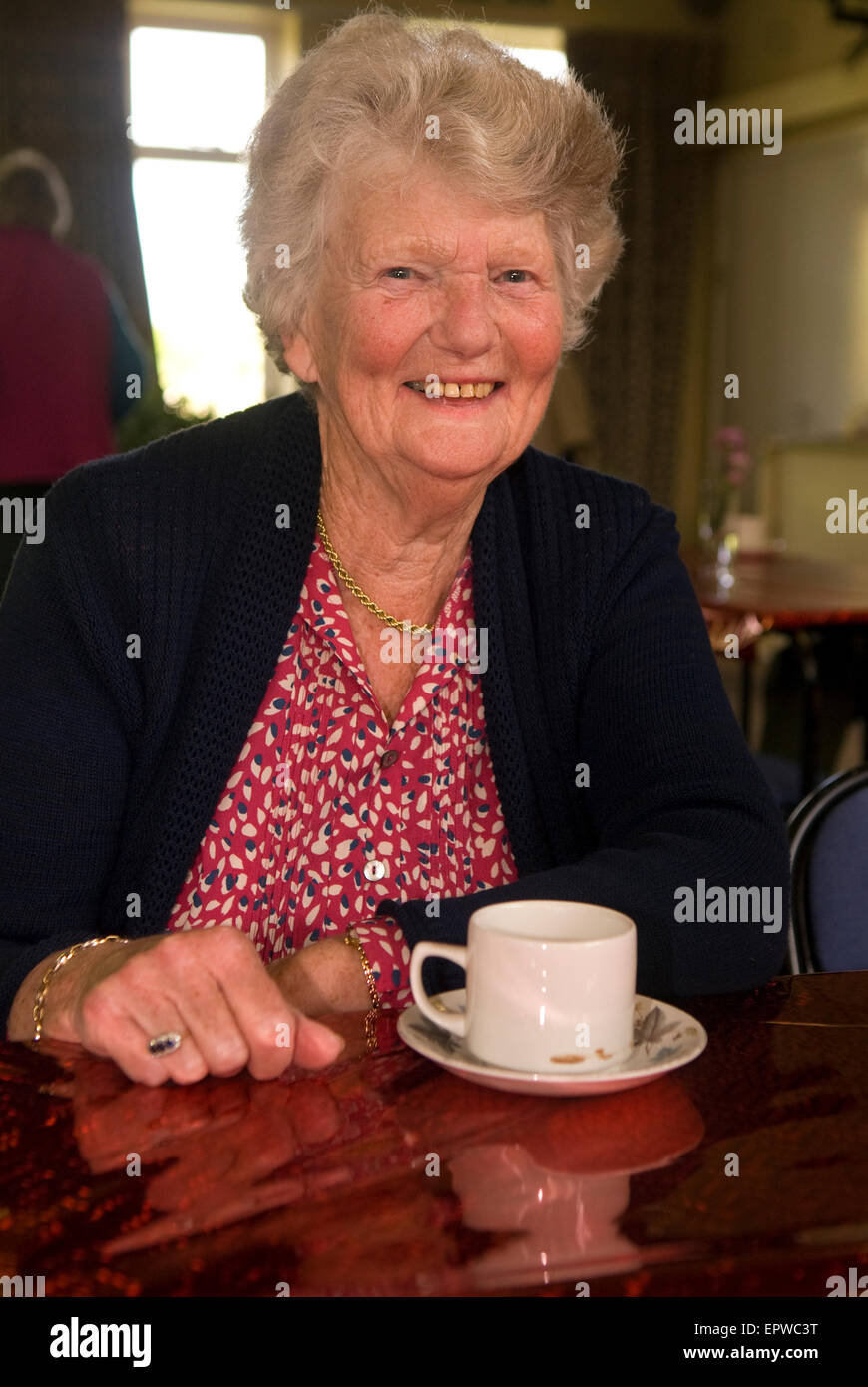 Ältere Frau genießen eine Tasse Tee am Morgen eine christliche Hilfe Woche Kaffee, um Gelder für wohltätige Zwecke, Liphook, Hampshire, UK. Stockfoto