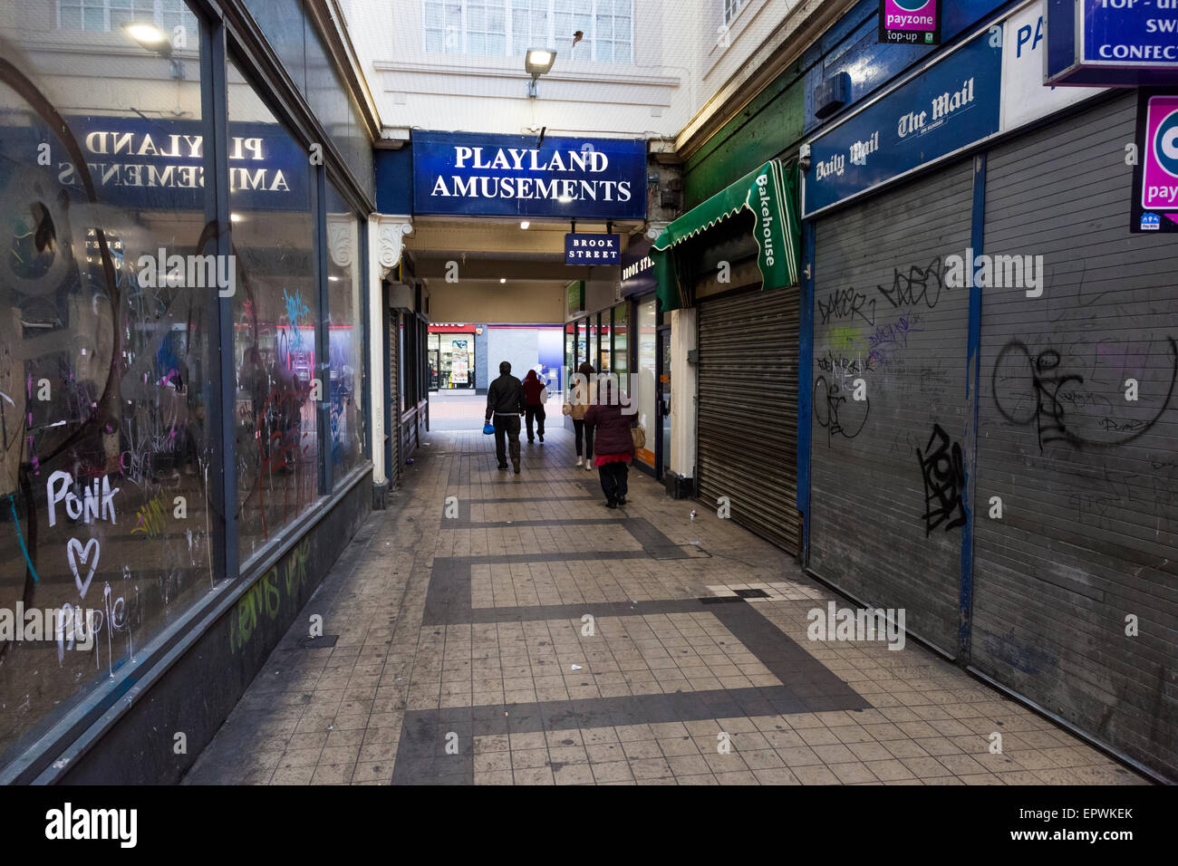 Vandalized Geschäften in einem heruntergekommen, schmutzig Stadtzentrum Arcade. Shop Fronten mit Graffiti auf Fenstern und Fensterläden. Der Park Street Arcade, Walsall, England, Großbritannien Stockfoto