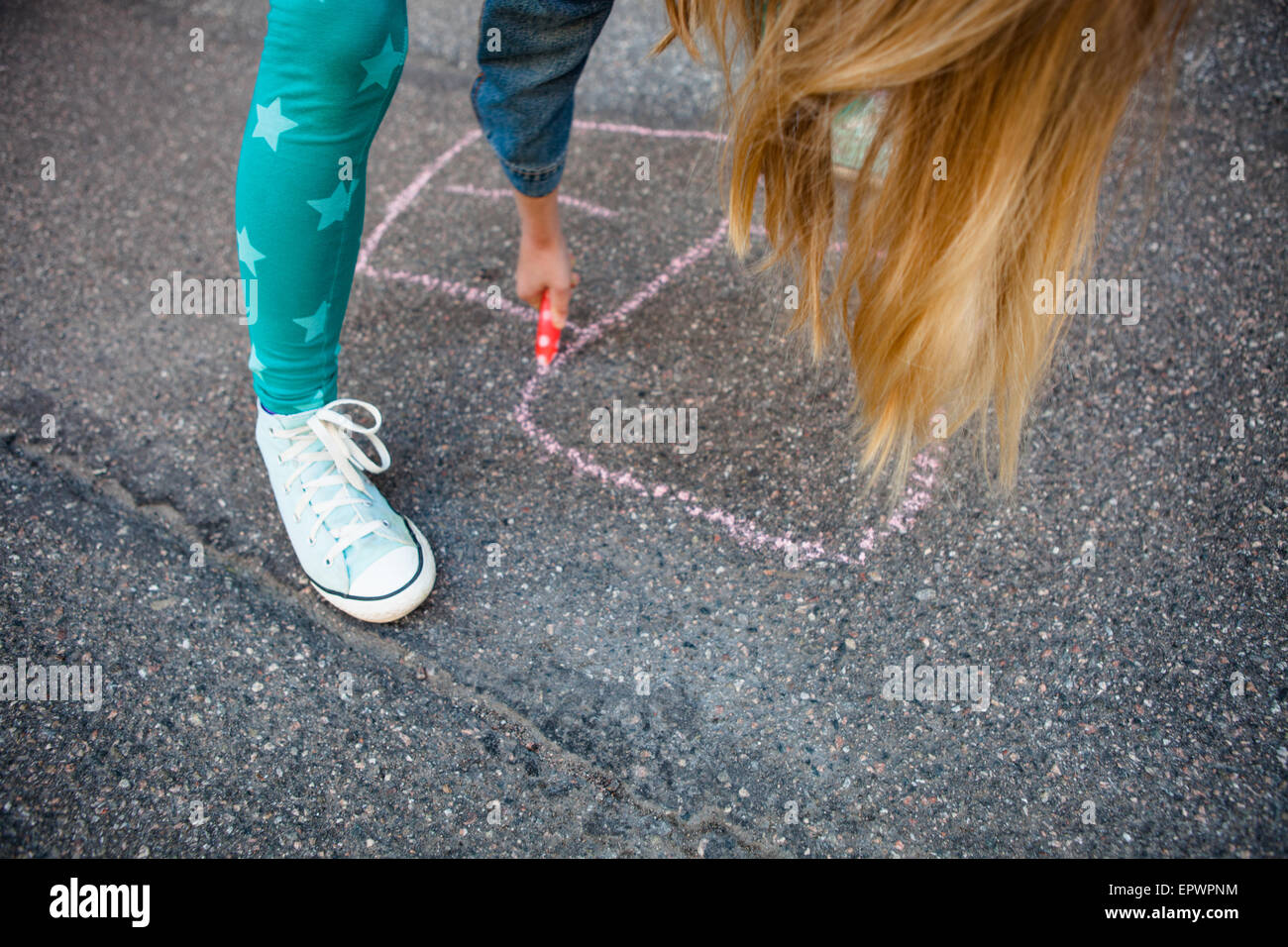Mädchen zeichnen ein Himmel und Hölle auf Asphalt mit Straße Kreide im freien Stockfoto