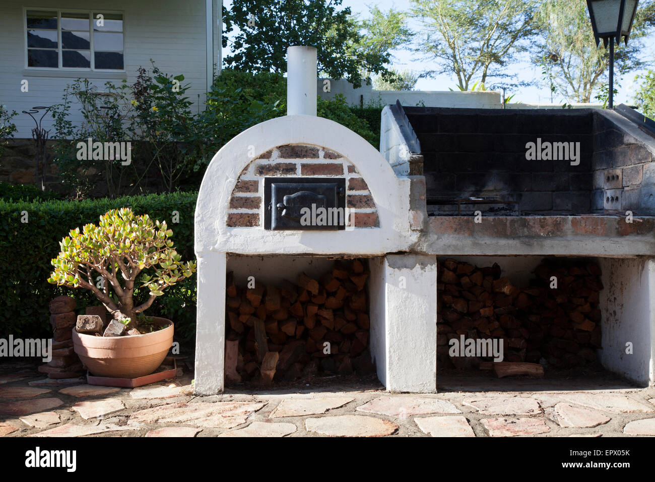 Weiß und Gesicht Ziegel Outdoor Brotbackofen und offenen Grill Grube mit Holz in südafrikanischen Heimat Stockfoto