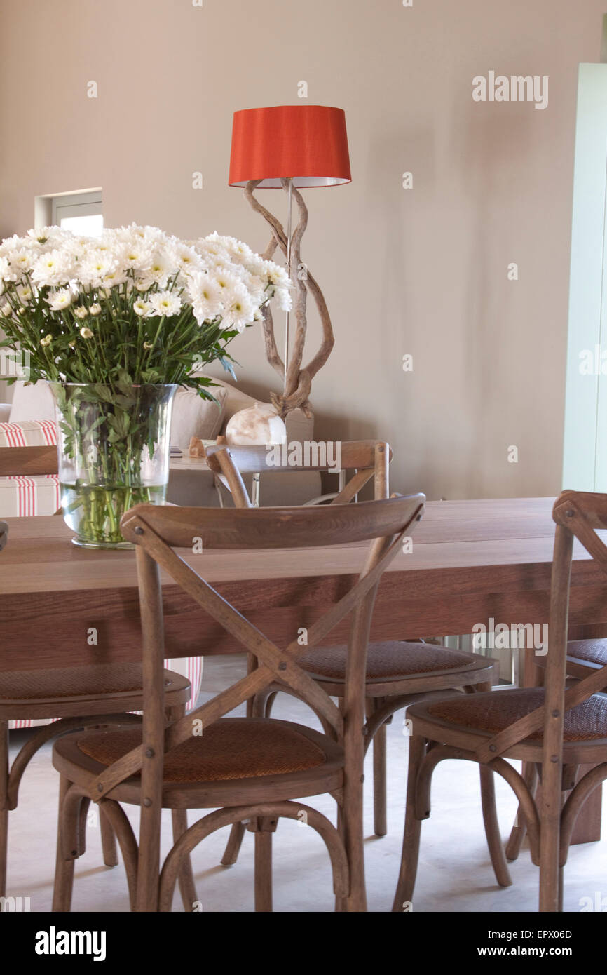 Esstisch und Stühle in Holz und Bambus mit Vase mit weißen Margeriten und  Treibholz rote Lampe im Hintergrund im südafrikanischen Strandhaus  Stockfotografie - Alamy