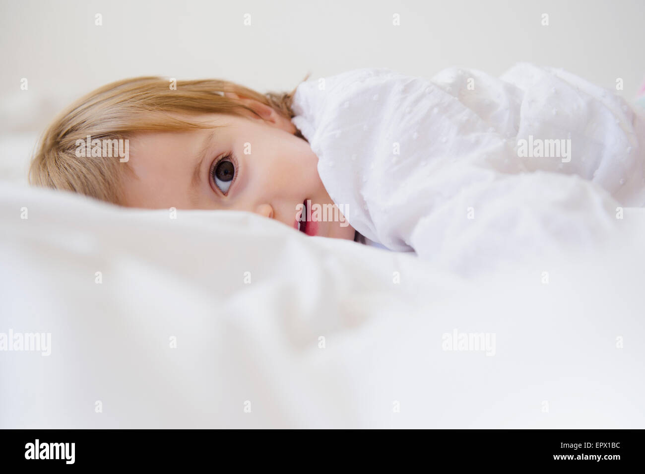 Mädchen (2-3) auf Bett liegend Stockfoto