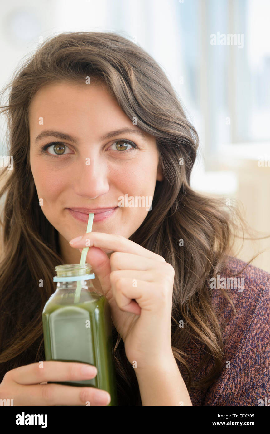 Porträt der Frau trinken Saft aus Flasche mit Stroh Stockfoto