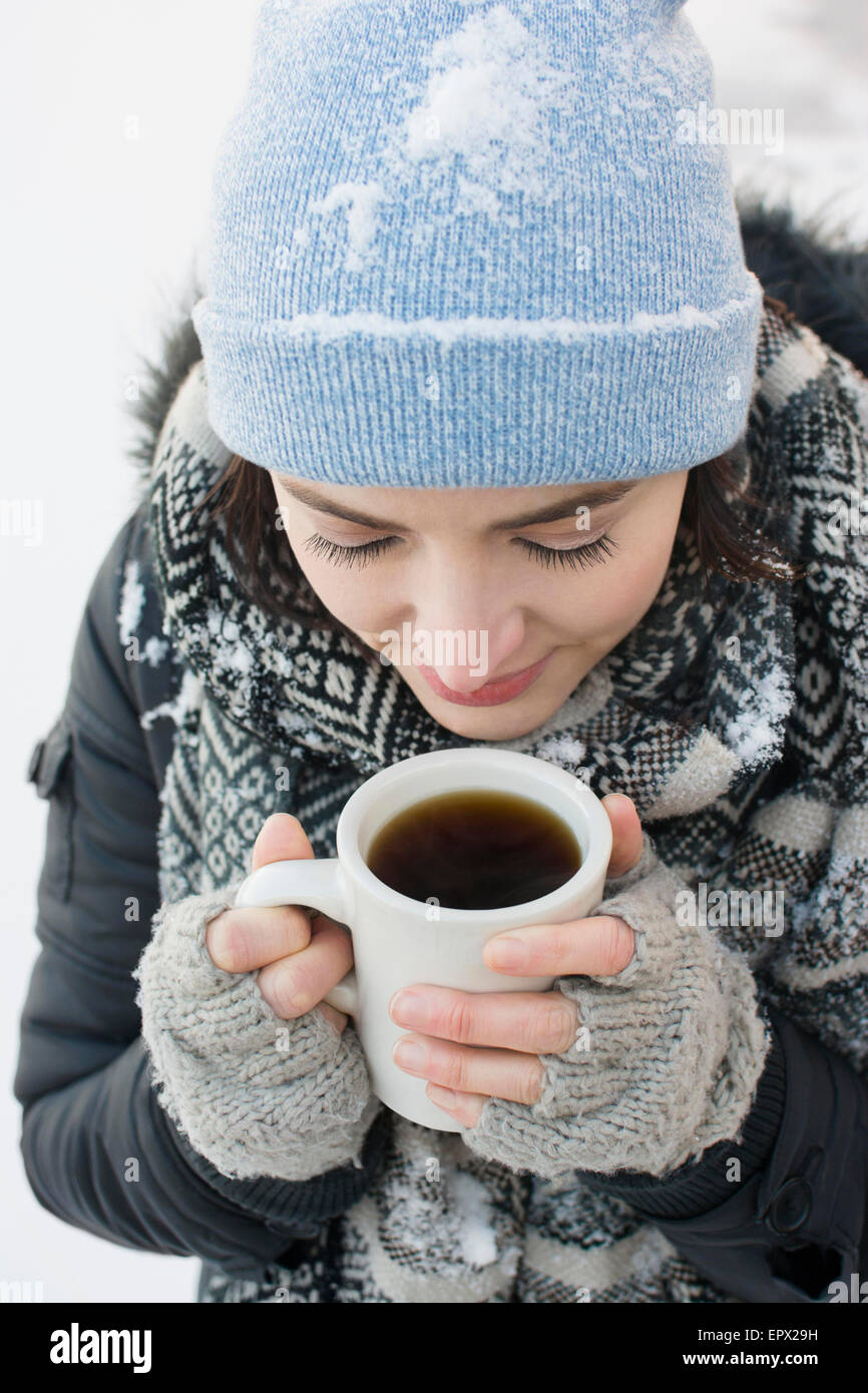 Frau mit Kaffeetasse im Schnee Stockfoto