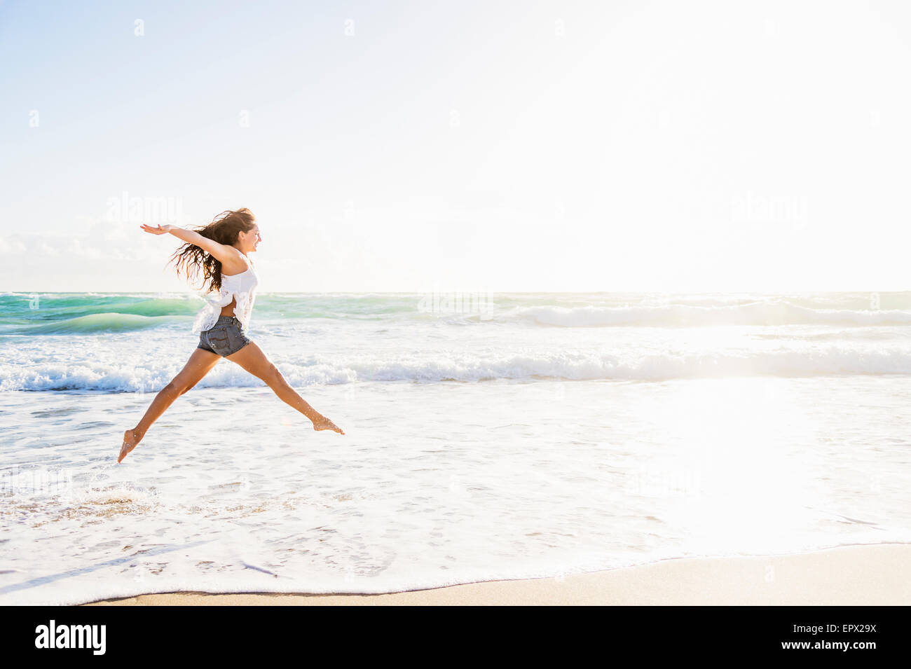 USA, Florida, Jupiter, Frau am Strand springen Stockfoto