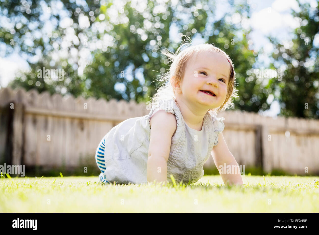 Babymädchen (6-11 Monate) Lachen im Hinterhof Stockfoto