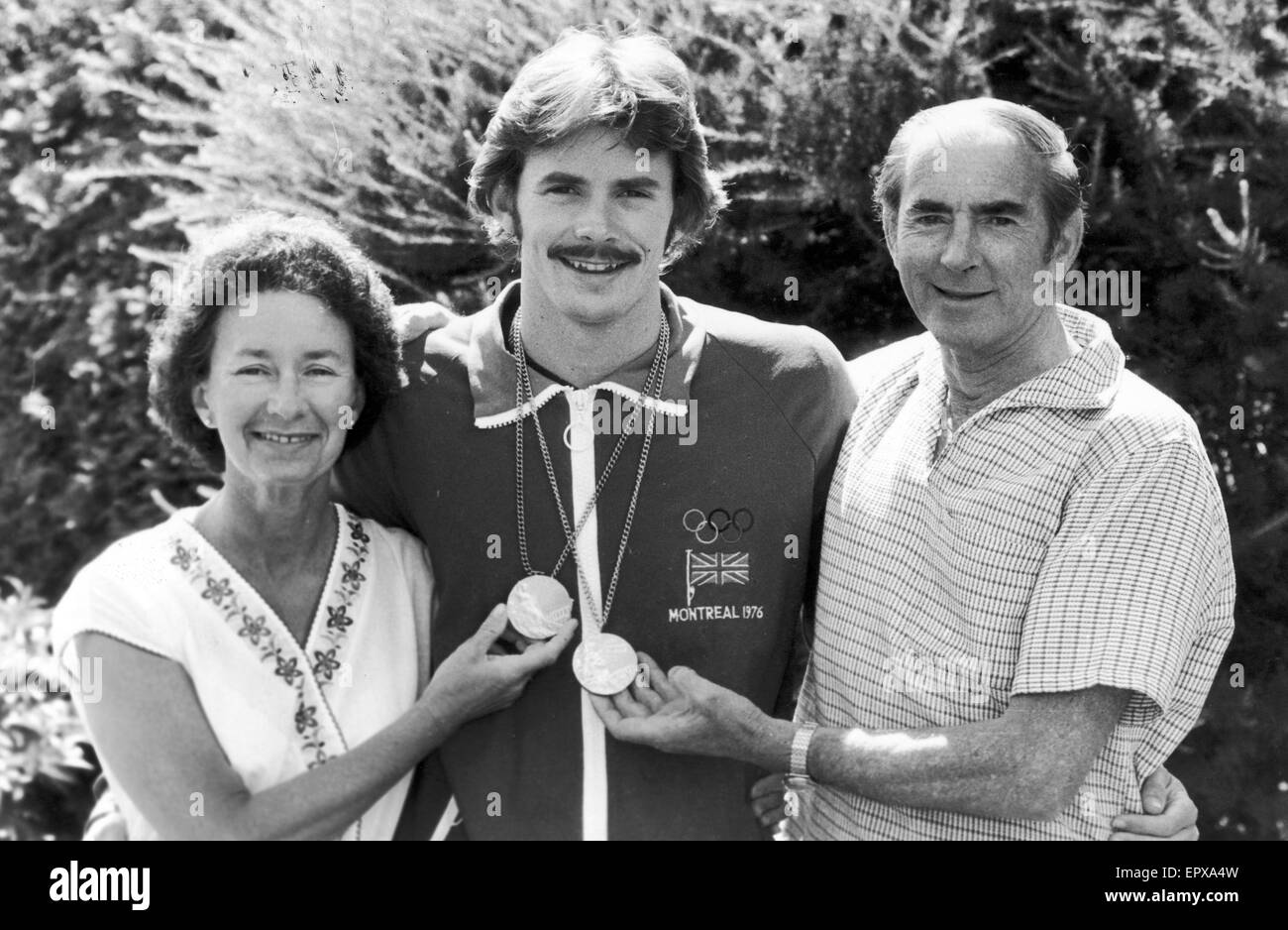 David Wilkie, Olympiasieger, 200 Meter Brustschwimmen, Olympischen Spiele in Montreal, Kanada, Juli 1976. Abgebildet mit Eltern in Montreal, zeigt stolz die Goldmedaille und Silbermedaille er danach holte im 100-Meter-Brustschwimmen. Stockfoto