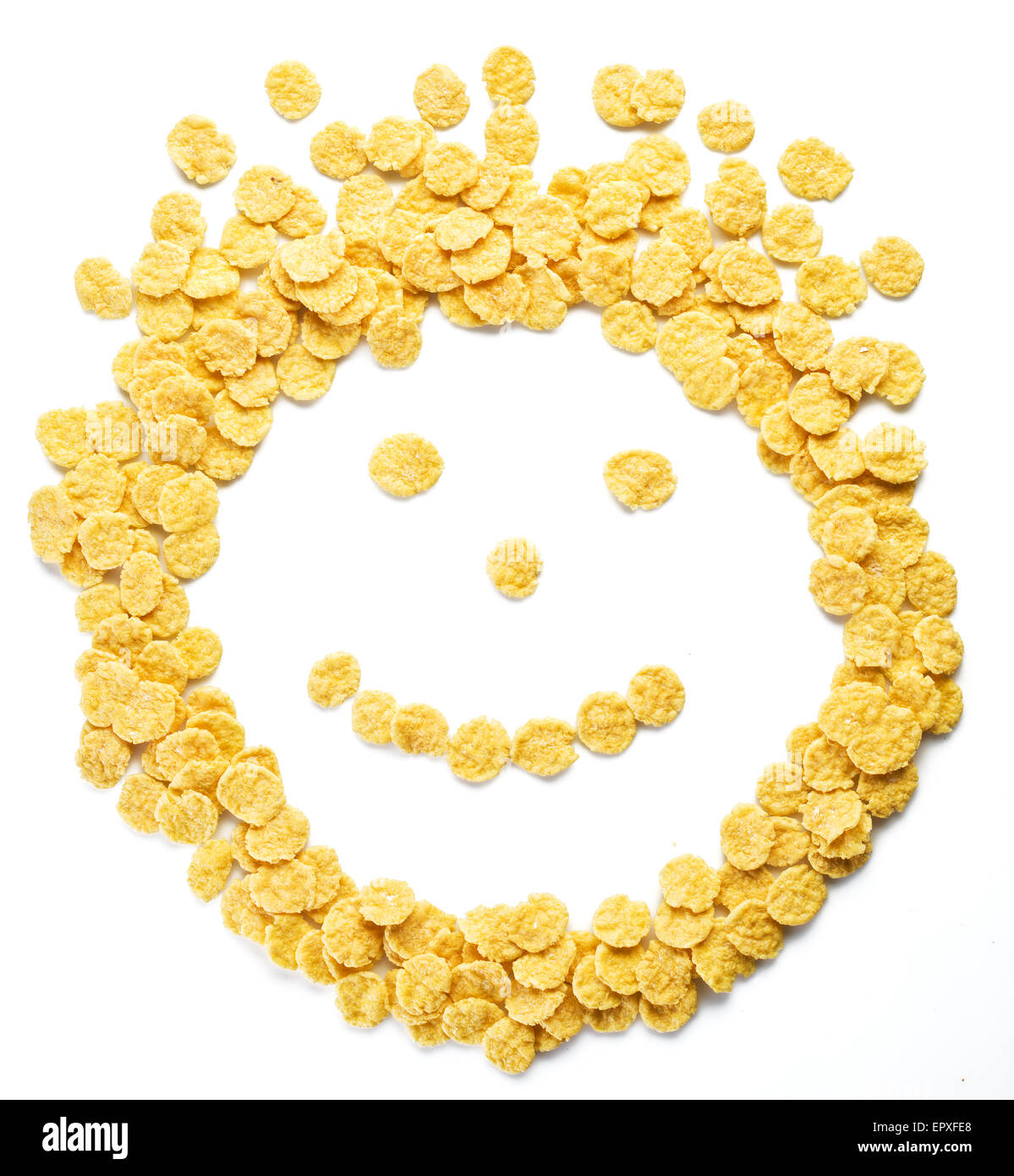 Cornflakes als Smiley-Gesicht auf einem weißen Hintergrund angeordnet. Stockfoto