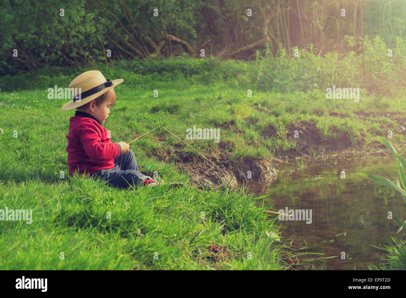 niedlichen kleinen Jungen spielen am Teich Stockfoto