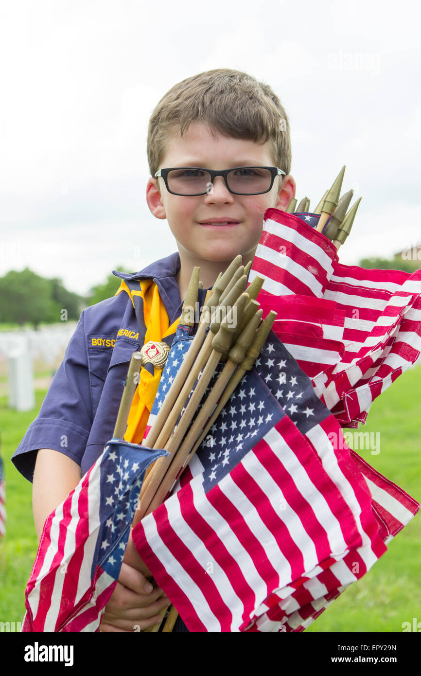 Ein Pfadfinder hält amerikanische Flaggen im Rahmen der Vorbereitungen der Gedenktag in Fort Sam Houston National Cemetery in Grabstätten stellen Stockfoto