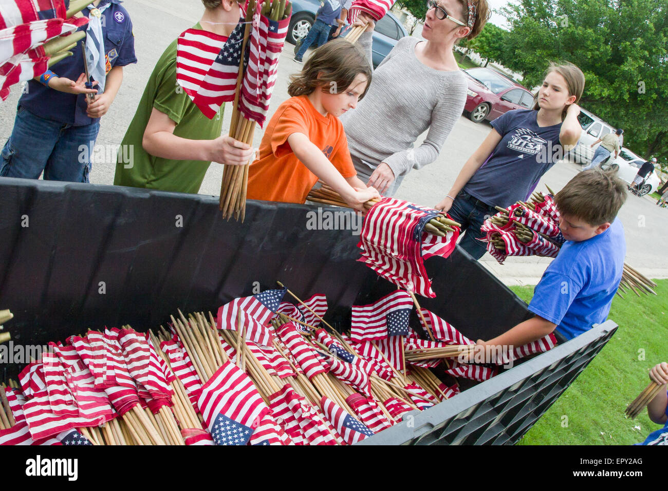 Freiwillige sammeln amerikanische Flaggen während der Memorial Day Vorbereitungen in Fort Sam Houston National Cemetery in Grabstätten stellen Stockfoto