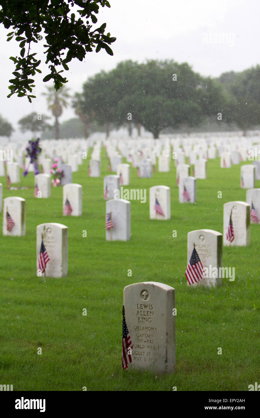 Starker Regen fällt auf amerikanische Flaggen frisch an Grabstätten von Freiwilligen in Vorbereitung für Memorial Day in Fort Sam Houston National Cemetery platziert. Stockfoto