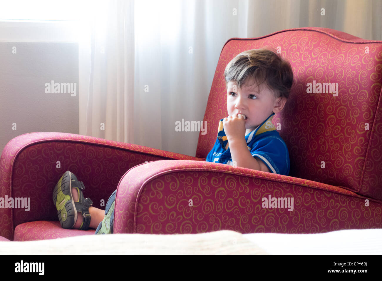 Junge auf einem Stuhl sitzend und vor dem Fernseher Stockfoto