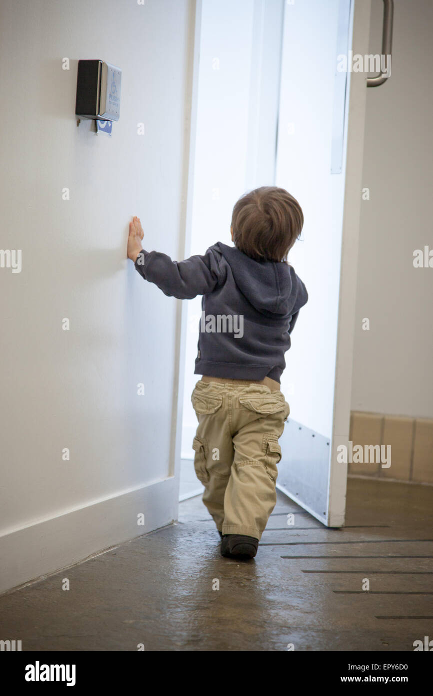 Junge mit einer Schlüsselkarte öffnen eine Tür Stockfoto