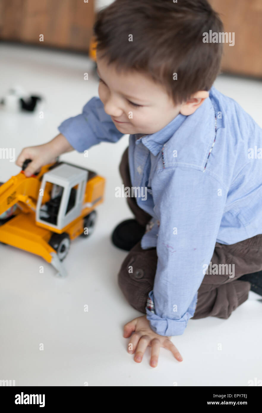 Niedliche kleine Junge spielt mit Kran Spielzeug bei Canon 5DmkII Homecolor image Stockfoto