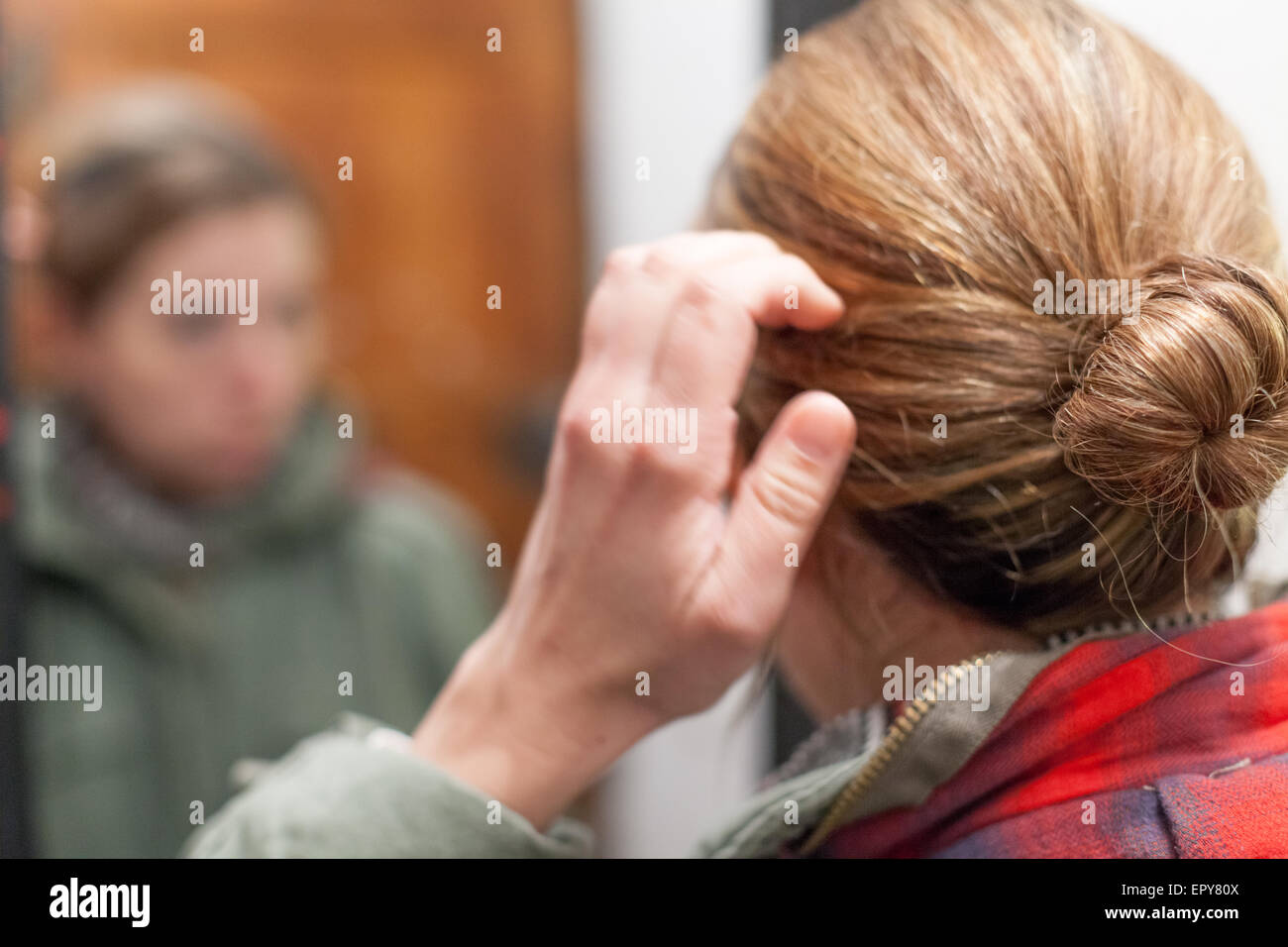 Rückansicht des Mitte Erwachsene Frau, die sich im Spiegelbild, Barcelona, Katalonien, Spaincolor, Canon 5DmkII bewundern Stockfoto