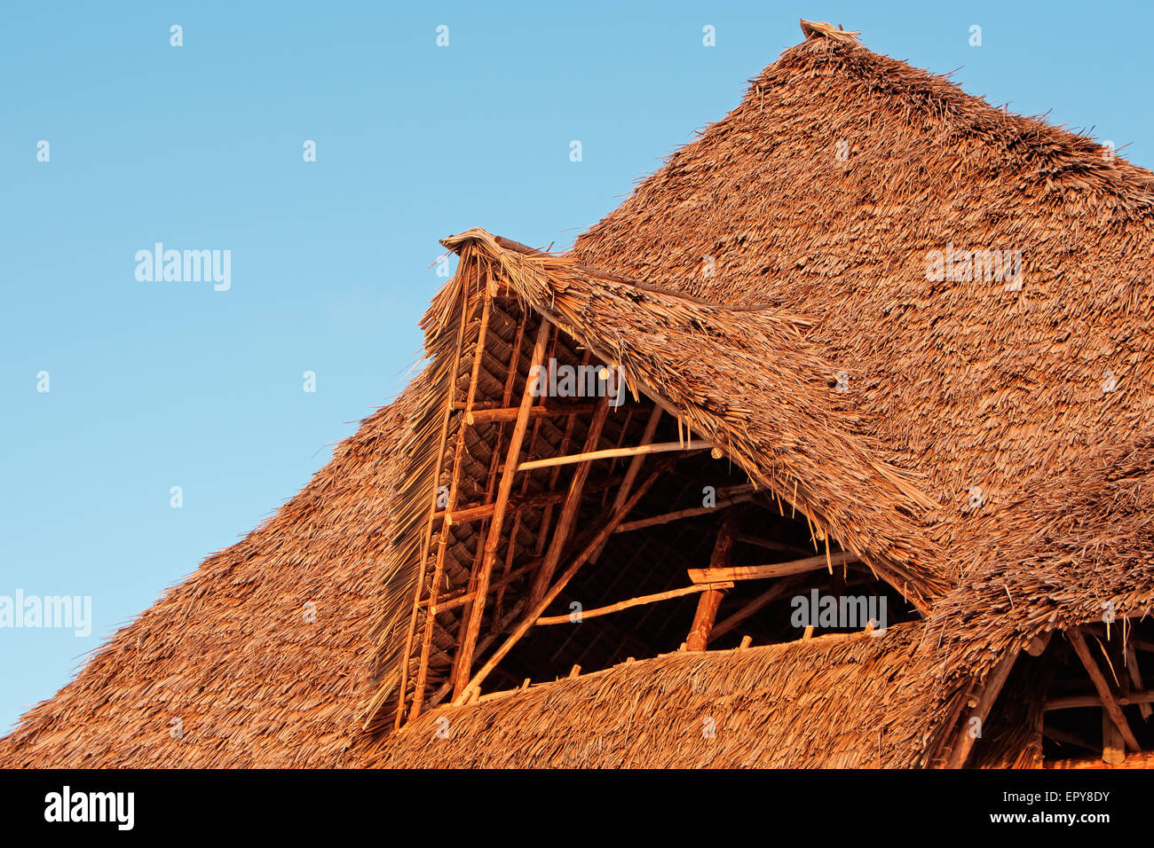 Rustikalen afrikanischen Strohdach vor blauem Himmel mit Wolken Stockfoto