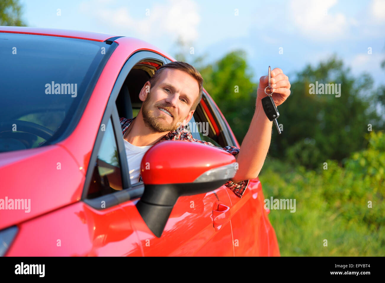 Mann in neue rote Auto mit Schlüssel. Stockfoto