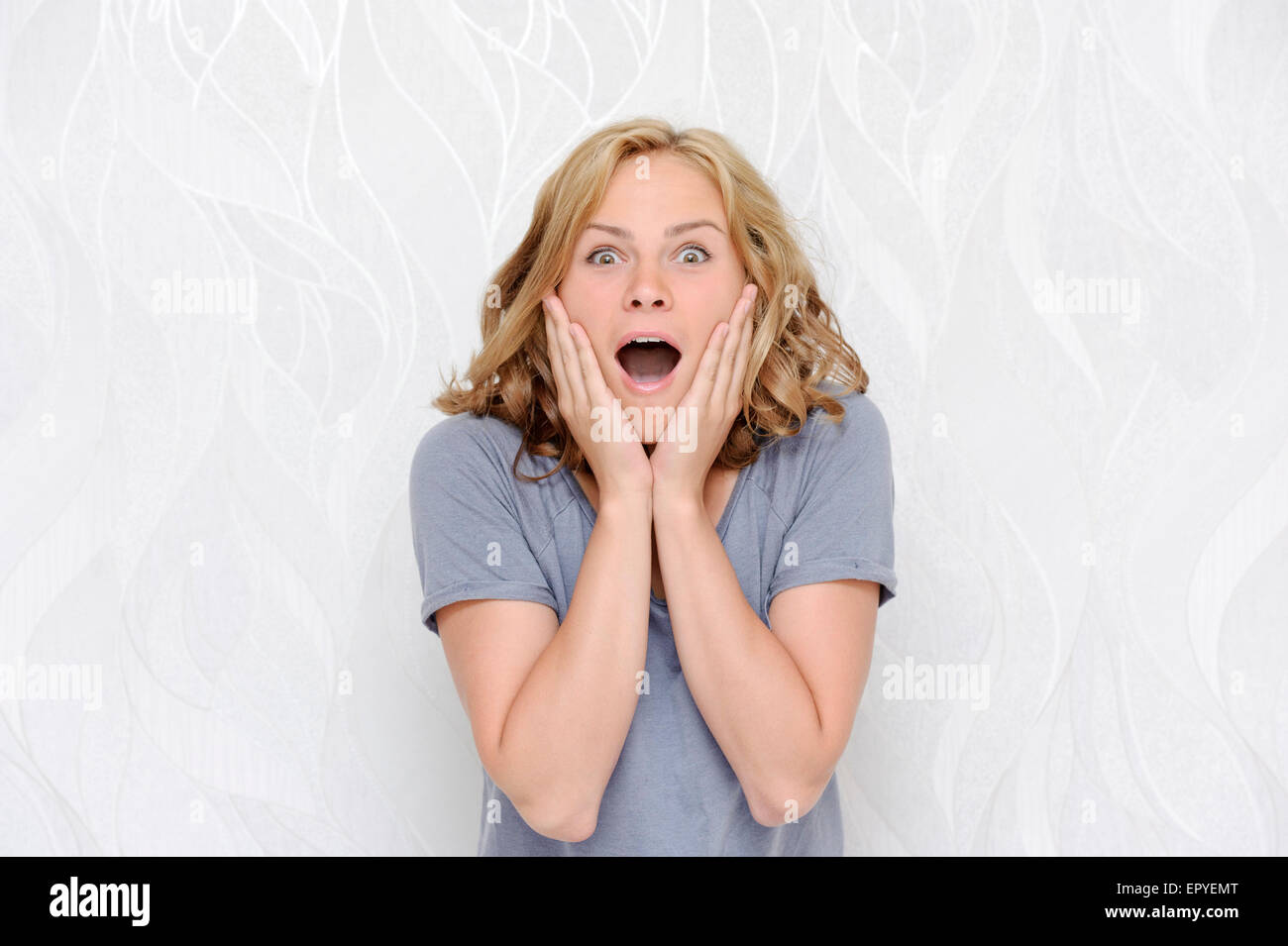 Junge Frau Gesicht verwundert berühren Stockfoto