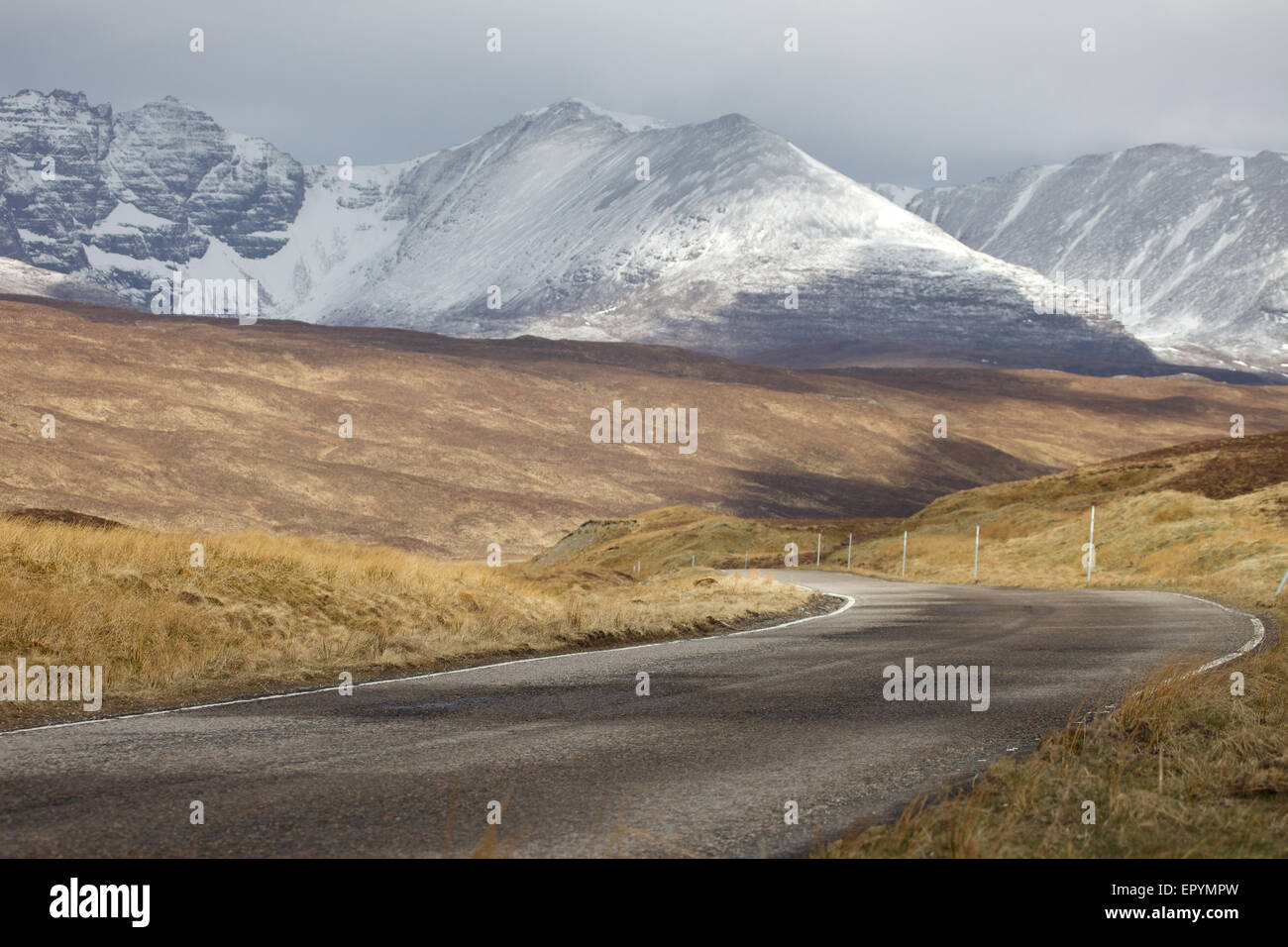 einsamen schottischen Straße geschwungene entfernt in Richtung Schnee bedeckt Berge Stockfoto