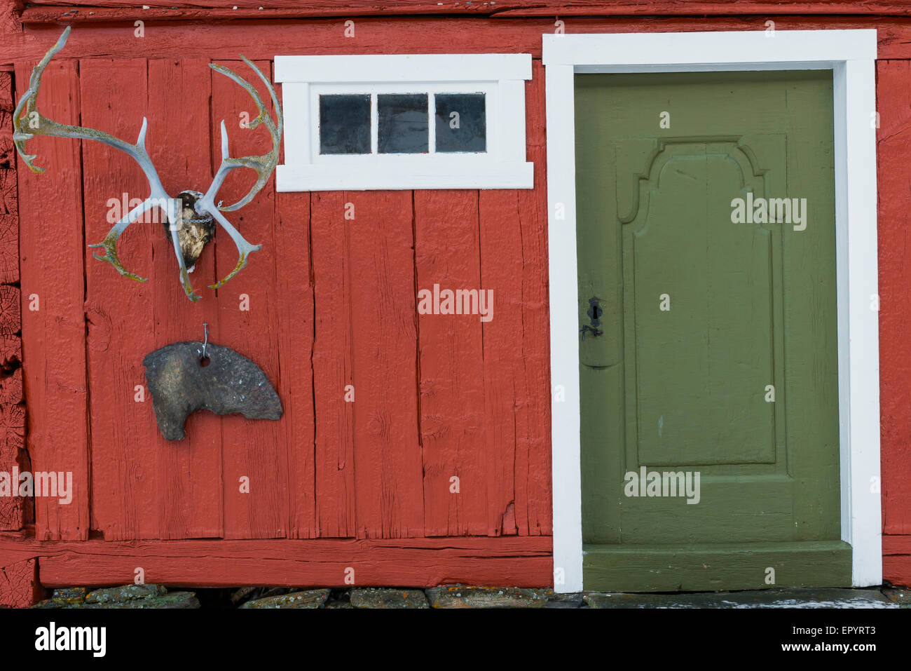 Alte rote Hütte mit grünen Tür im Dovrefjell Nationalpark in Hjerkinn, Norwegen. Stockfoto